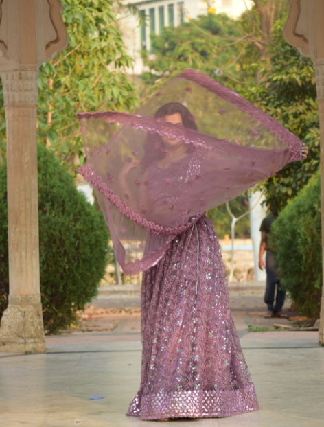 A model wearing lilac designer lehenga choli with designer dupatta