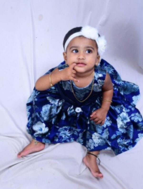 A baby wearing navy blue printed frock with white hair band- Girl dresses & Frocks