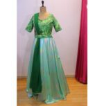 Emerald green designer lehenga with shimmering Lycra fabric, paired with a designer blouse, a bead-embellished waist belt, and a georgette dupatta, perfect for weddings and festive occasions.